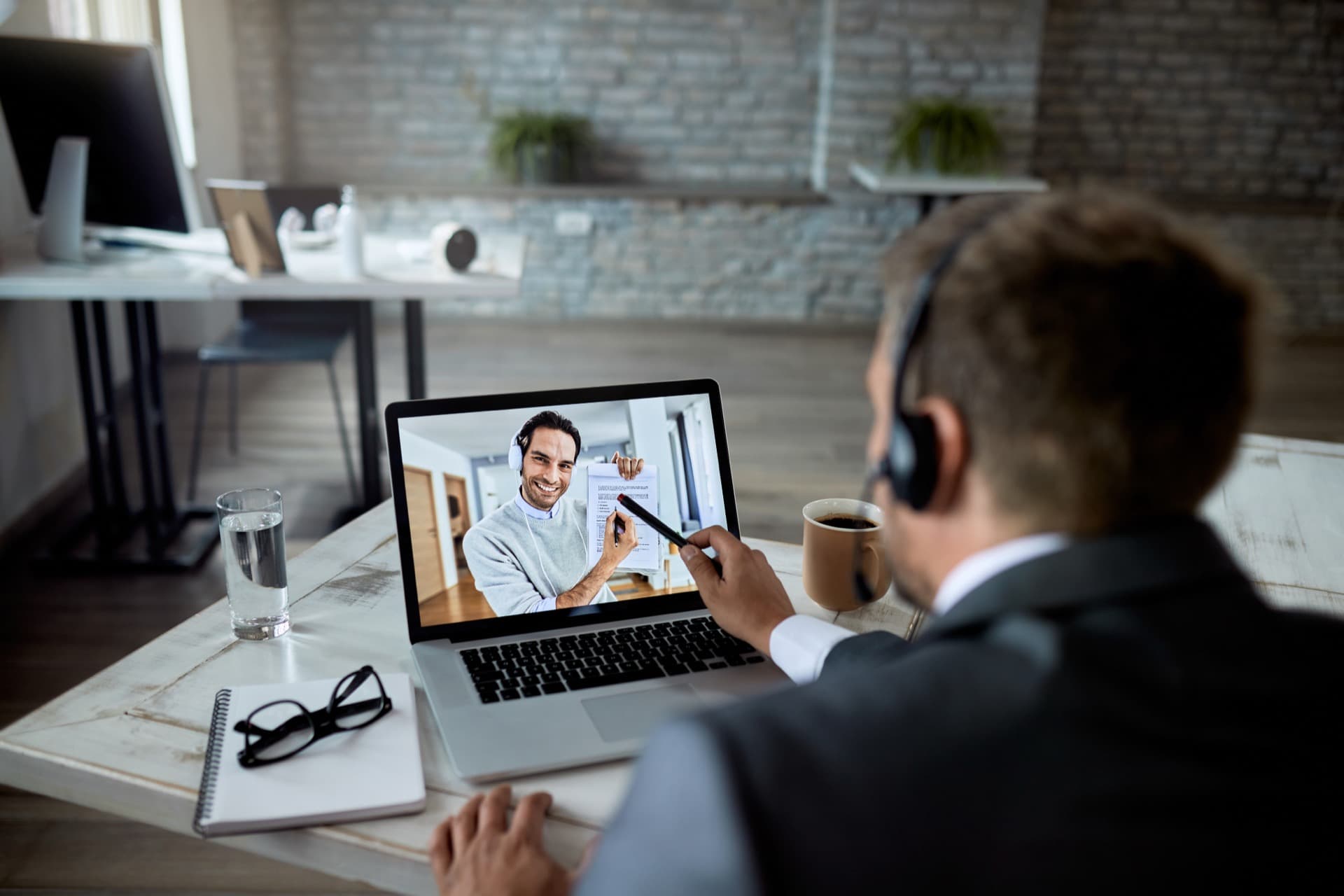 A counsellor on a video call reviewing documents with a student