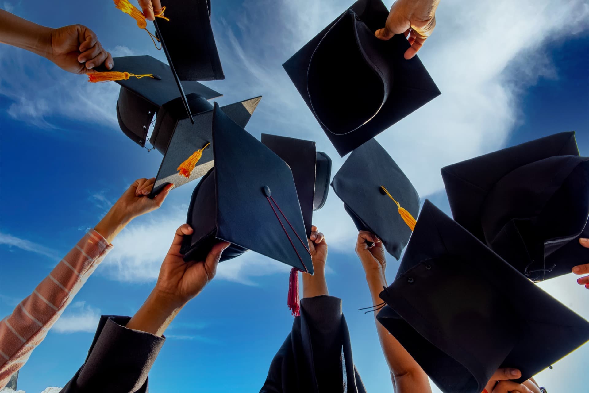 Graduates tossing caps into the air
